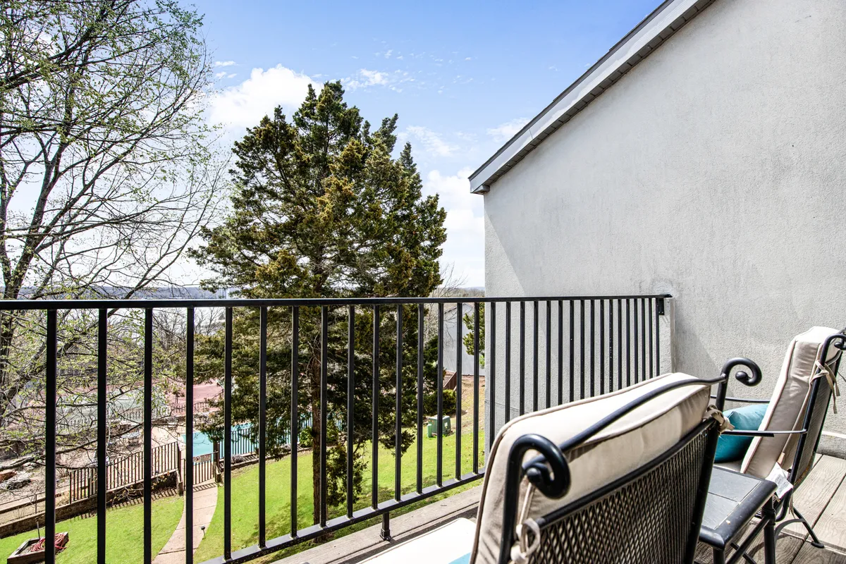 The photo spotlights a balcony seating area framed by a railing and offering a scenic landscape view. The inviting setup suggests morning coffee, reading, or planning the day’s adventures while enjoying the outdoors.